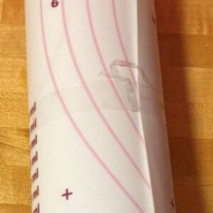 Close-up of a white and pink patterned item on a wooden surface.