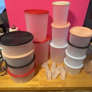 A collection of various plastic storage containers and lids on a table.