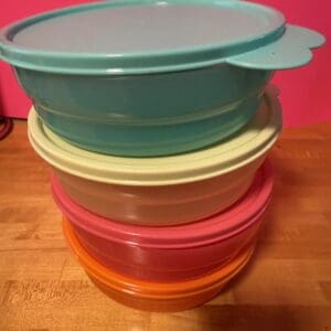 Stacked colorful plastic food storage containers with lids.