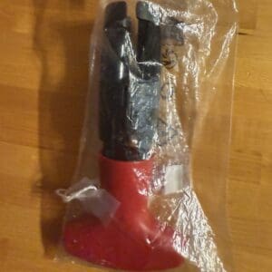 Red and black handheld tool sealed in plastic packaging.