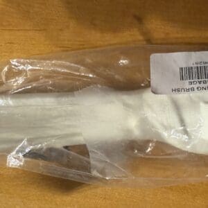 White, packaged fabric item with a label on a wooden surface.