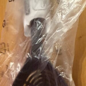Black frying pan wrapped in a clear plastic bag.