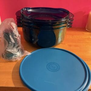 Blue food storage containers with lids and a sealed bag of accessories.