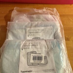 Stack of packaged medical or laboratory supplies on a wooden surface.
