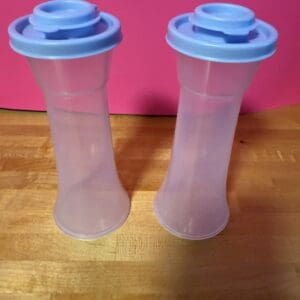 Two translucent plastic bottles with blue lids on a wooden surface.