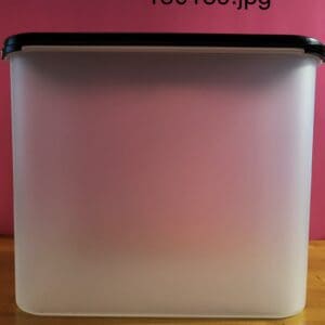 Square translucent container with a black lid on a pink background.