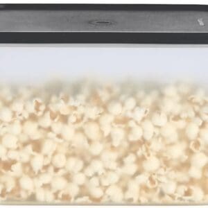 A close-up of popcorn popping inside a microwave.